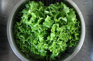 Photo of Colander with fresh wet lettuce in sink, top view