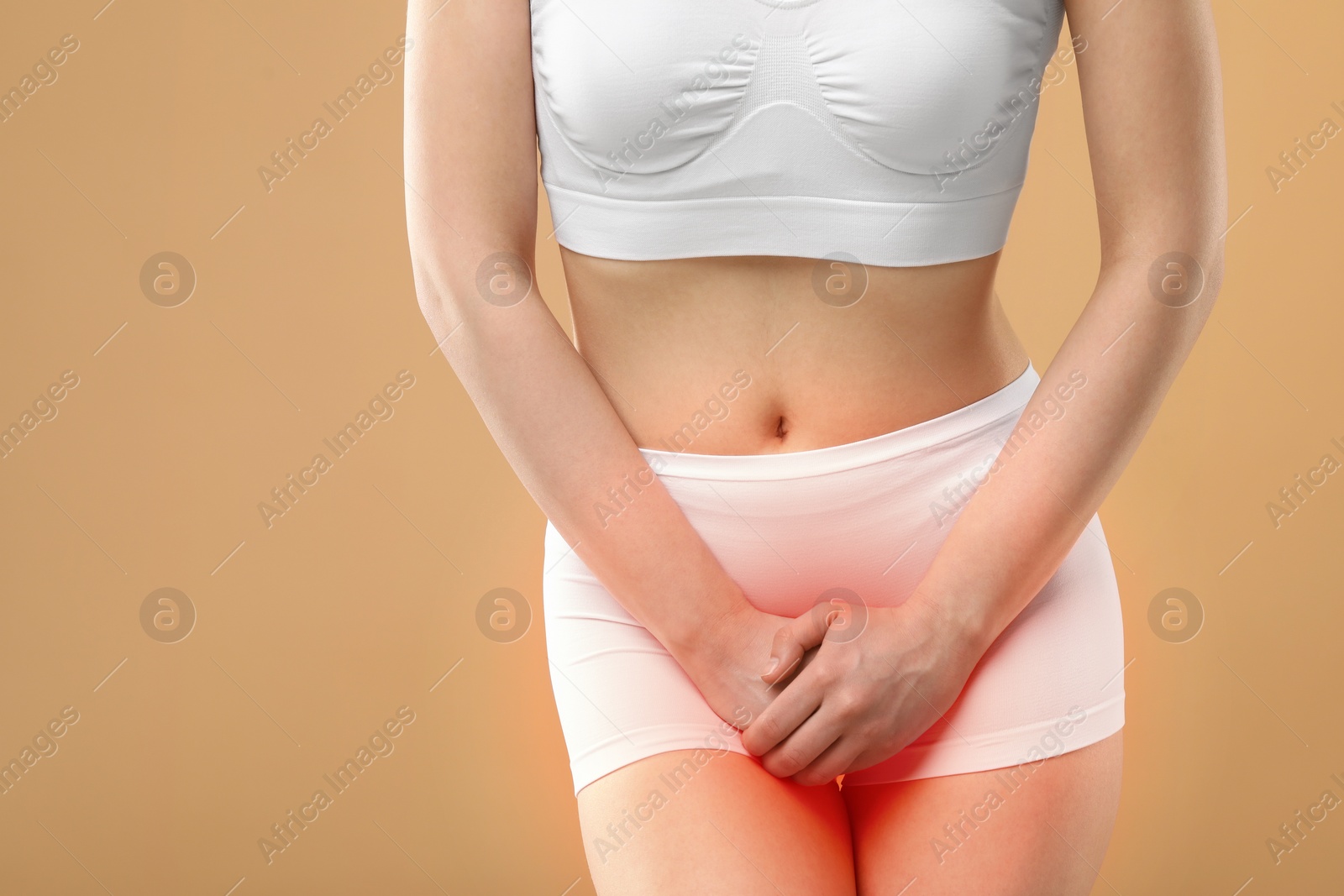 Image of Woman suffering from cystitis symptoms on beige background, closeup