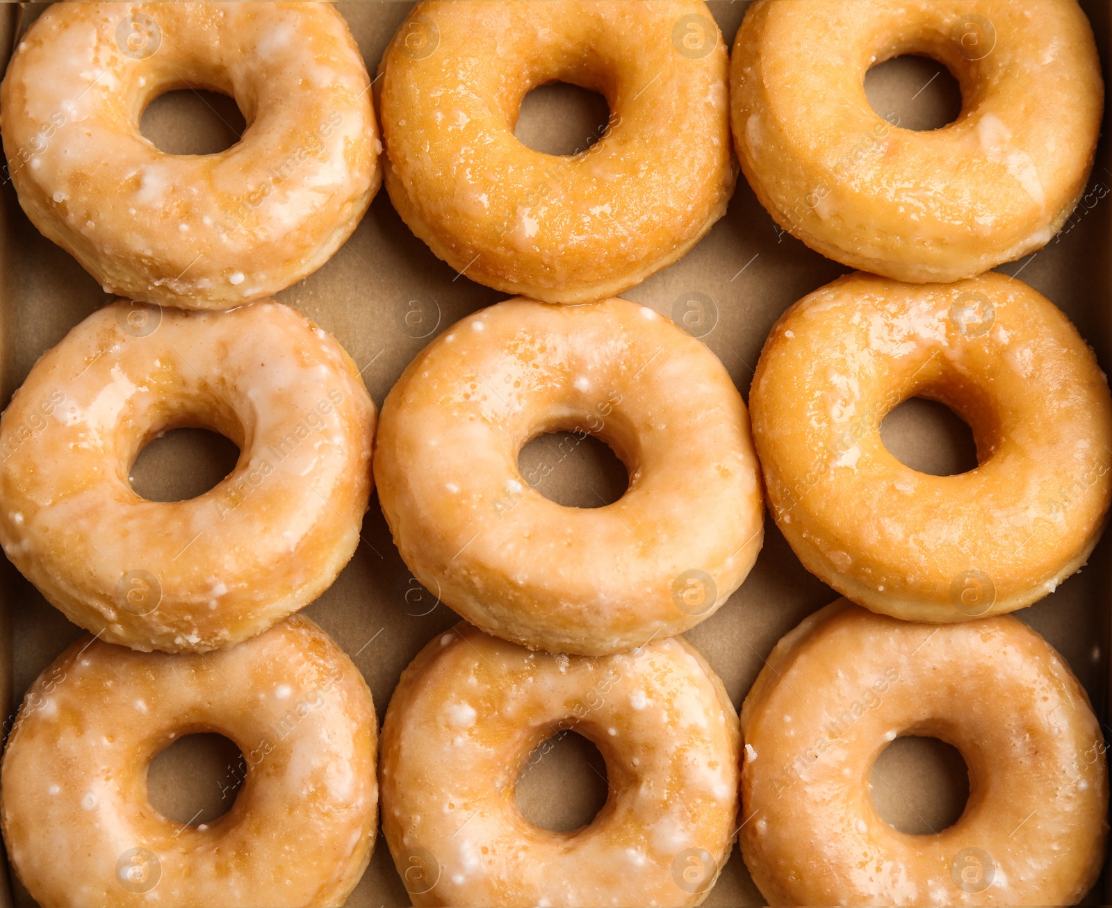 Photo of Delicious donuts on white wooden table, top view