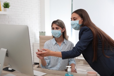 Office employees in respiratory masks at workplace