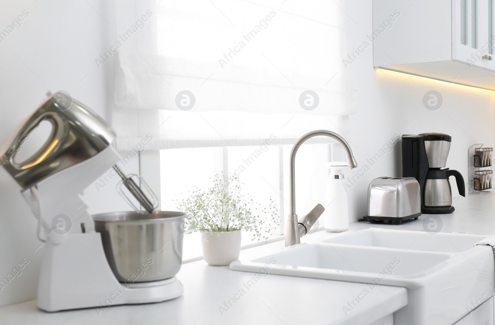 Photo of Modern toaster and household appliances on counter in kitchen