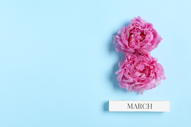 International Women's day. 8th of March made with beautiful peonies on light blue background, top view. Space for text