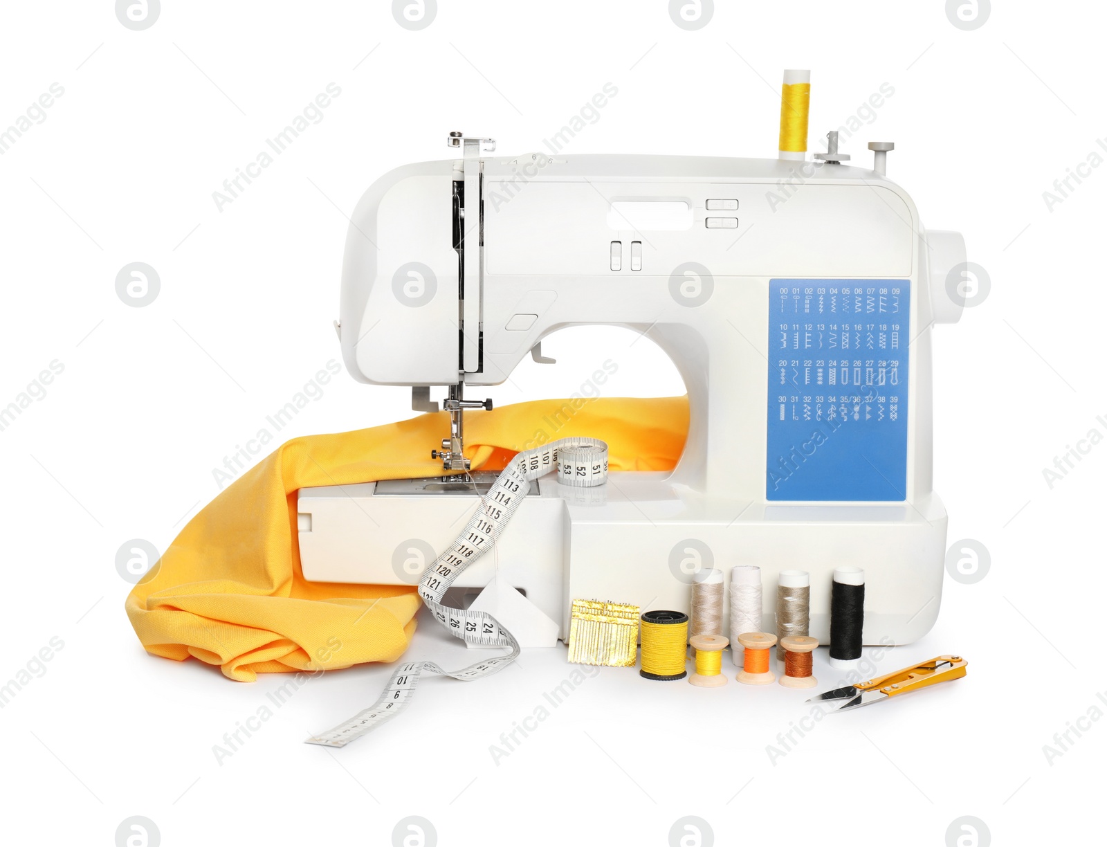 Photo of Modern sewing machine with yellow cloth and craft accessories isolated on white