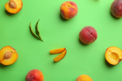 Flat lay composition with fresh peaches on green background