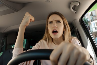 Photo of Stressed angry woman in driver's seat of modern car