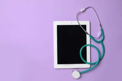 Tablet and stethoscope on lilac background, top view with space for text. Gynecology care