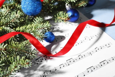 Composition with Christmas decor and music sheets on table, closeup