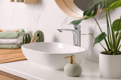 Stylish vessel sink on light countertop in modern bathroom