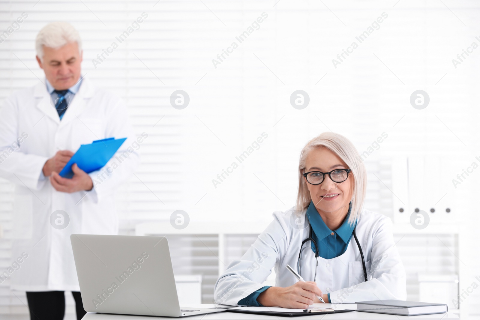 Photo of Portrait of mature female doctor in white coat at workplace