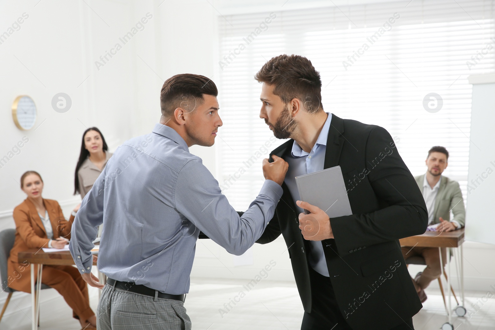 Photo of Emotional colleagues fighting in office. Workplace conflict