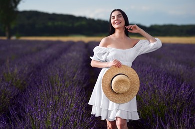 Beautiful young woman walking in lavender field