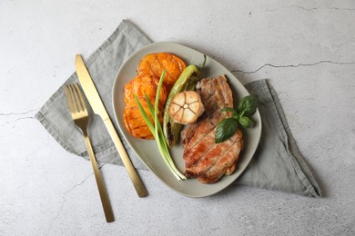 Photo of Delicious grilled meat and vegetables served on light grey table, flat lay