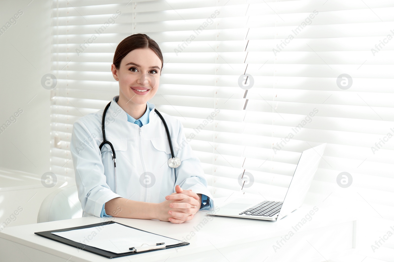 Photo of Portrait of young female doctor in white coat at workplace