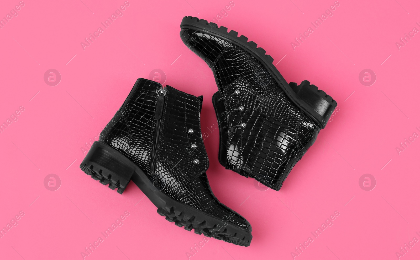 Photo of Pair of stylish ankle boots on pink background, top view