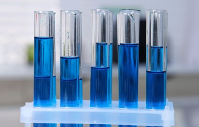 Laboratory analysis. Test tubes with blue liquid indoors, closeup