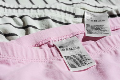 Photo of Clothing labels with instructions on garments, closeup