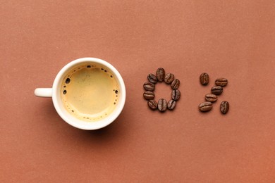 Photo of 0 percent made of beans and cup with coffee on color background, flat lay. Decaffeinated drink