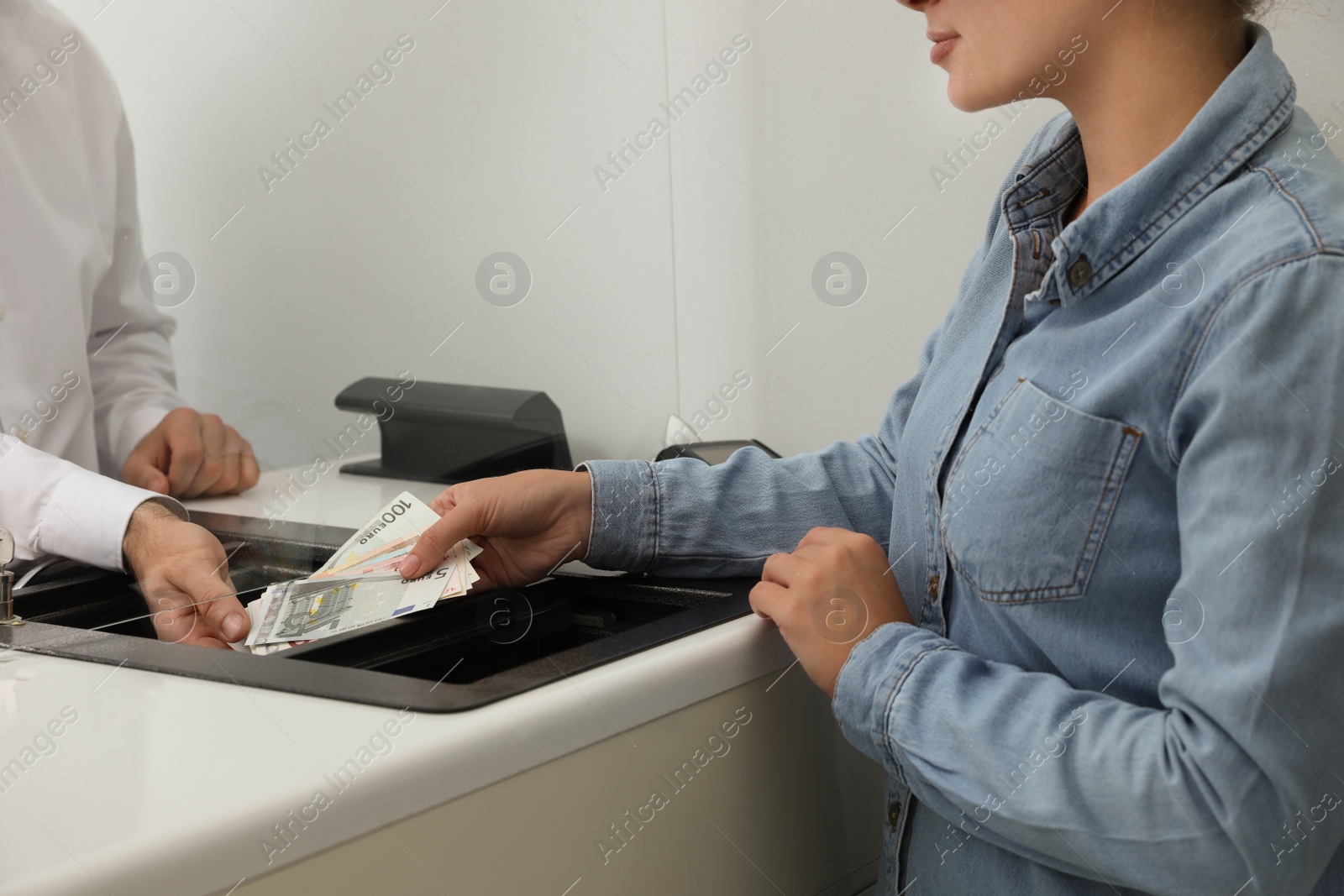 Photo of Woman giving money to cashier in bank, closeup. Currency exchange