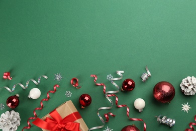 Photo of Flat lay composition with serpentine streamers and Christmas decor on green background. Space for text