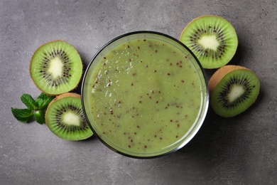 Photo of Delicious kiwi smoothie and fresh fruits on grey table, flat lay