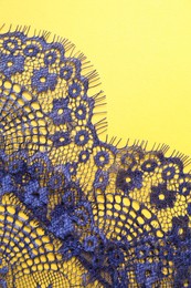 Blue lace on yellow background, top view