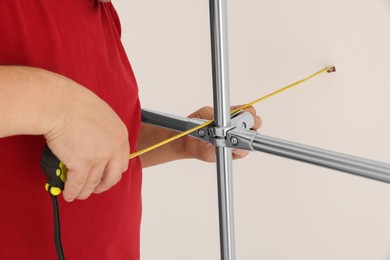 Worker measuring metal pipes for installation, closeup