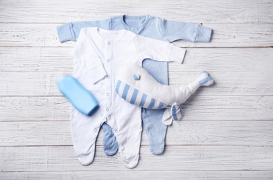 Photo of Flat lay composition with baby clothes and accessories on wooden background