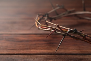 Crown of thorns on wooden table, closeup with space for text. Easter attribute
