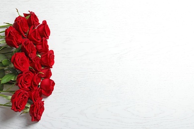 Photo of Beautiful red rose flowers on wooden background, top view