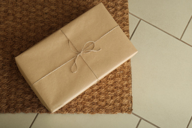 Photo of Parcel on rug near doorway. Delivery service