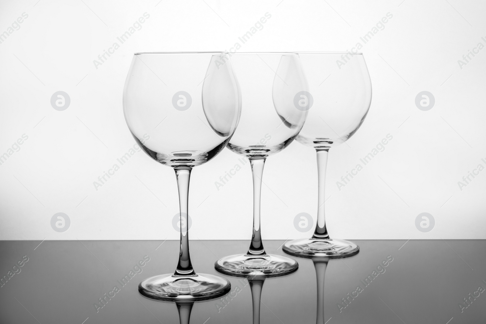 Photo of Row of empty wine glasses on white background
