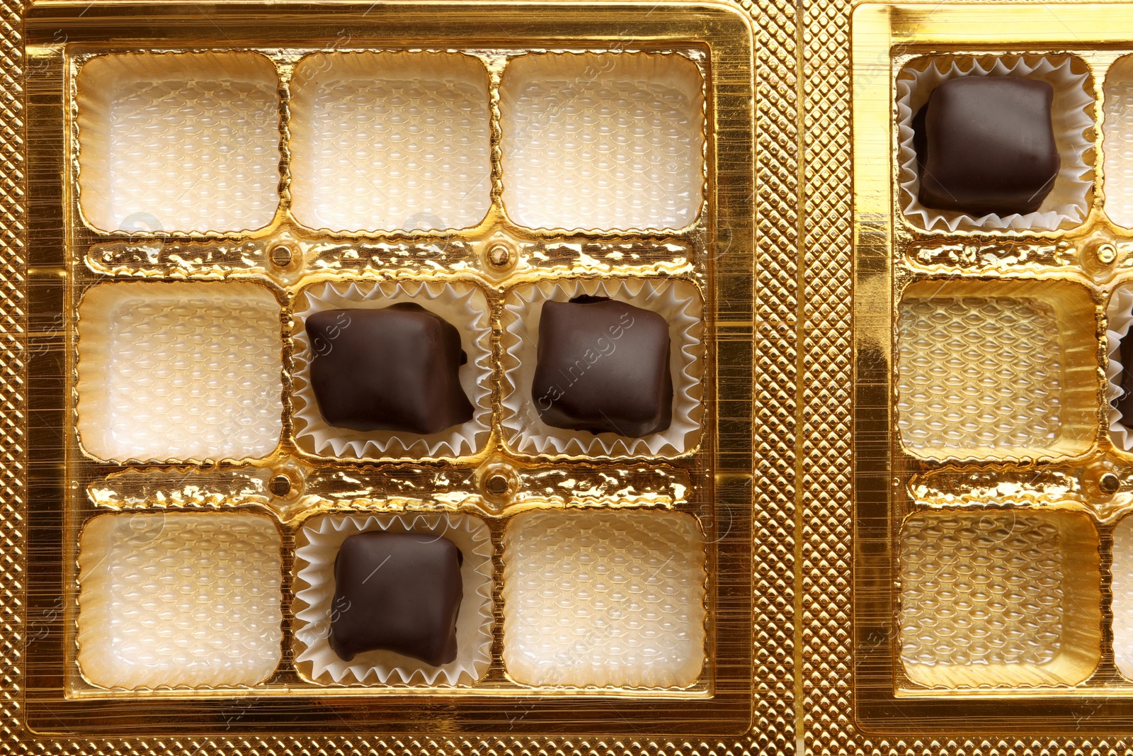 Photo of Partially empty box of chocolate candies as background, top view