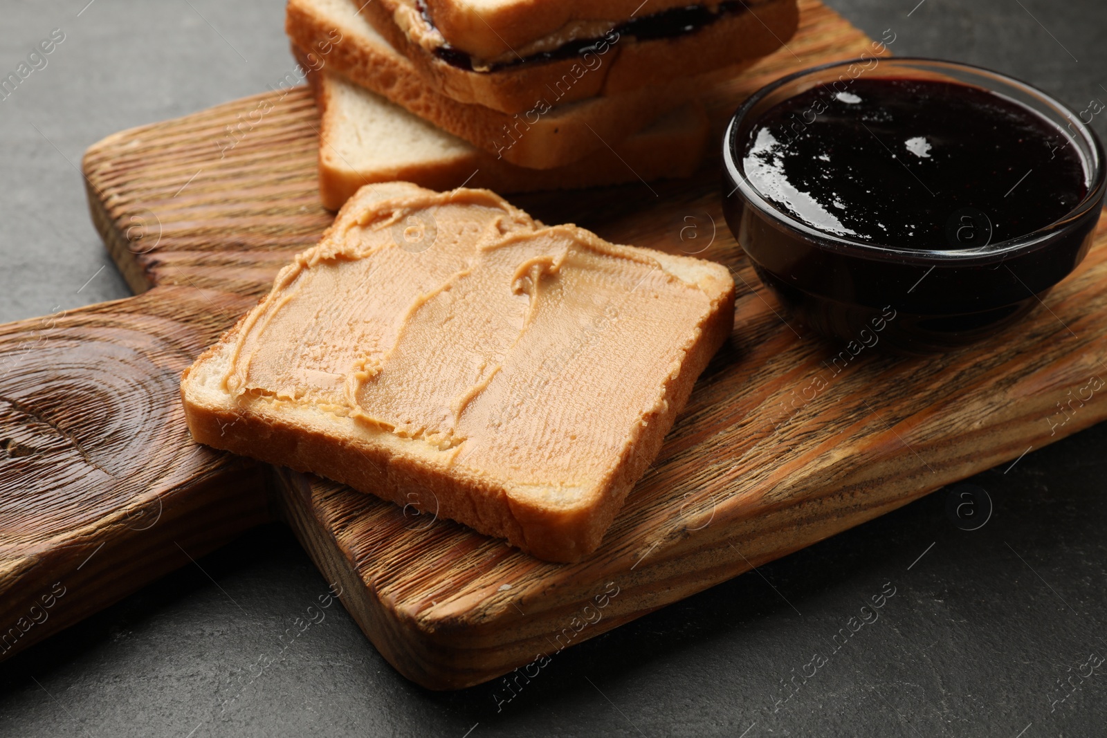 Photo of Tasty peanut butter sandwiches with jam on table, closeup