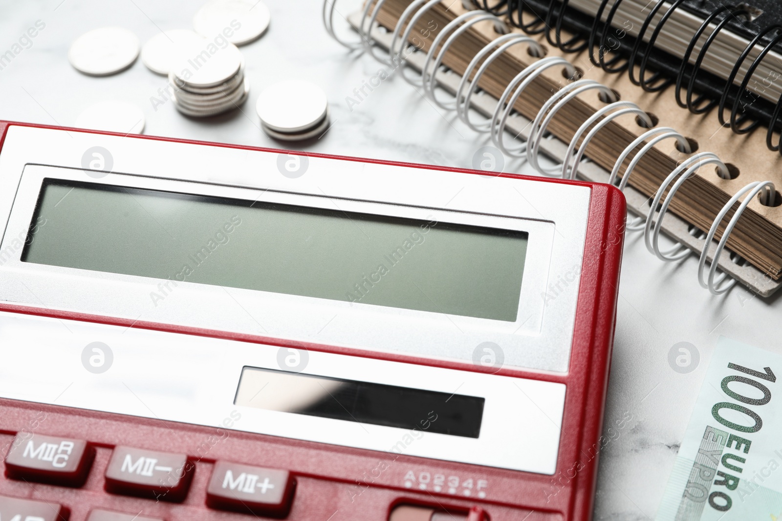 Photo of Calculator, money and notebooks on marble table, closeup. Tax accounting