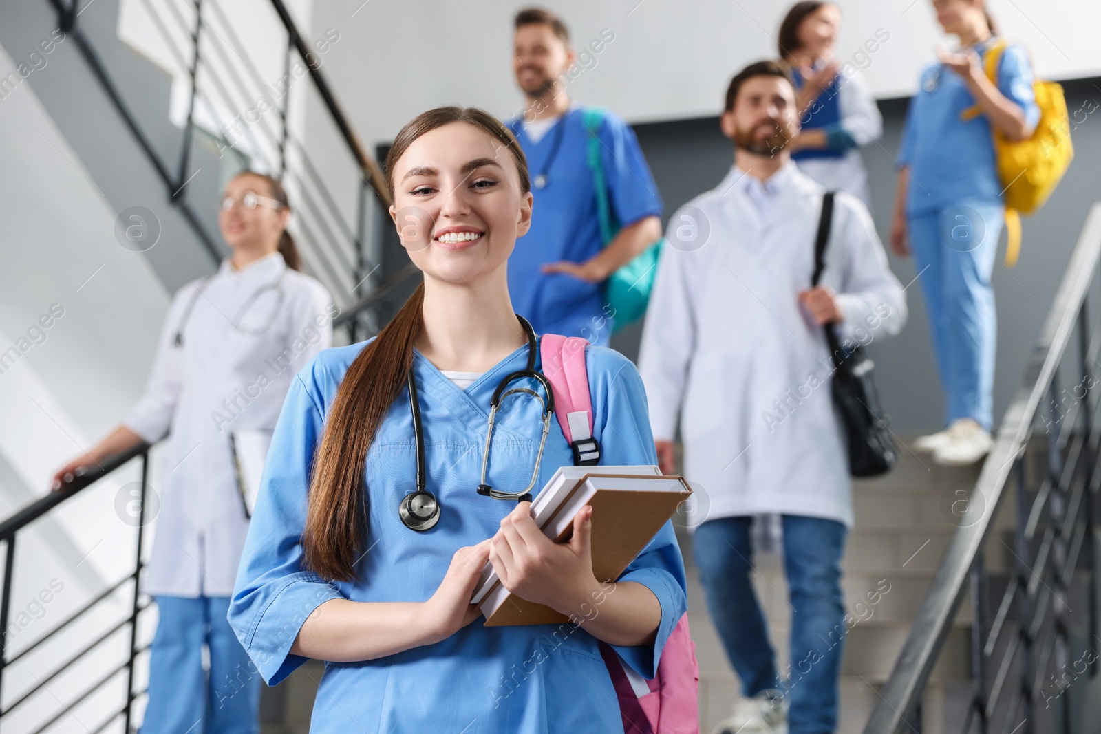 Photo of Portrait of medical student with books on staircase in college, space for text