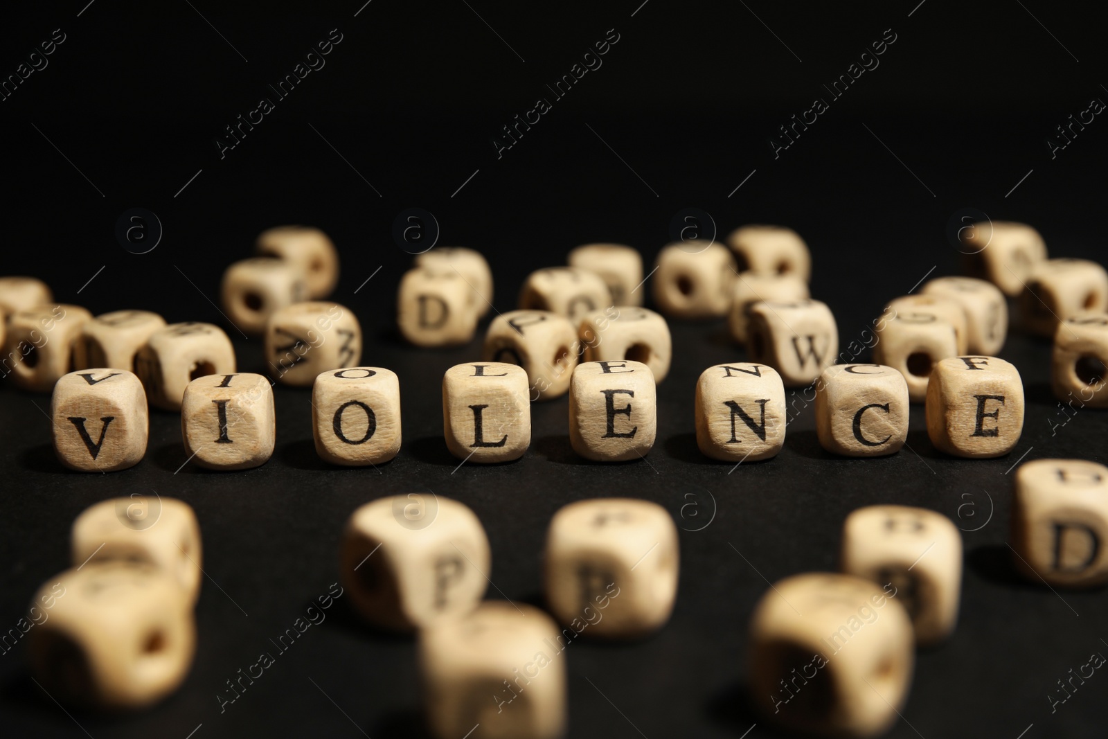 Photo of Word VIOLENCE made of wooden cubes on black background