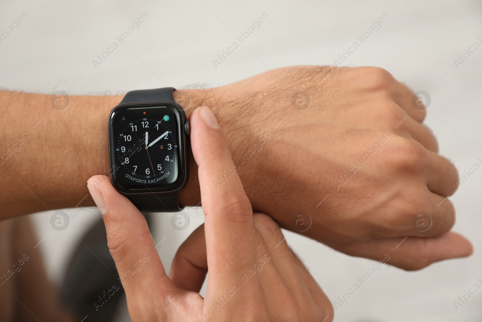 Image of MYKOLAIV, UKRAINE - OCTOBER 04, 2019: Man using Apple Watch to check time on light background, closeup