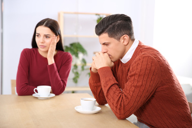 Couple with relationship problems at table in cafe