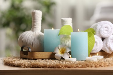 Composition with different spa products and burning candles on table