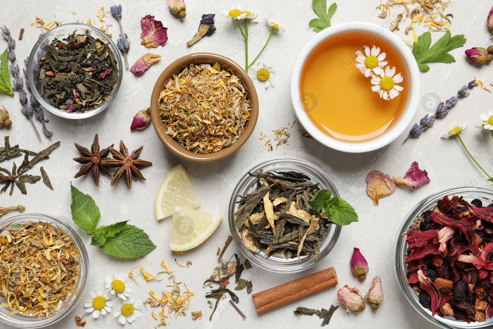 Photo of Flat lay composition with fresh brewed tea and dry leaves on light table