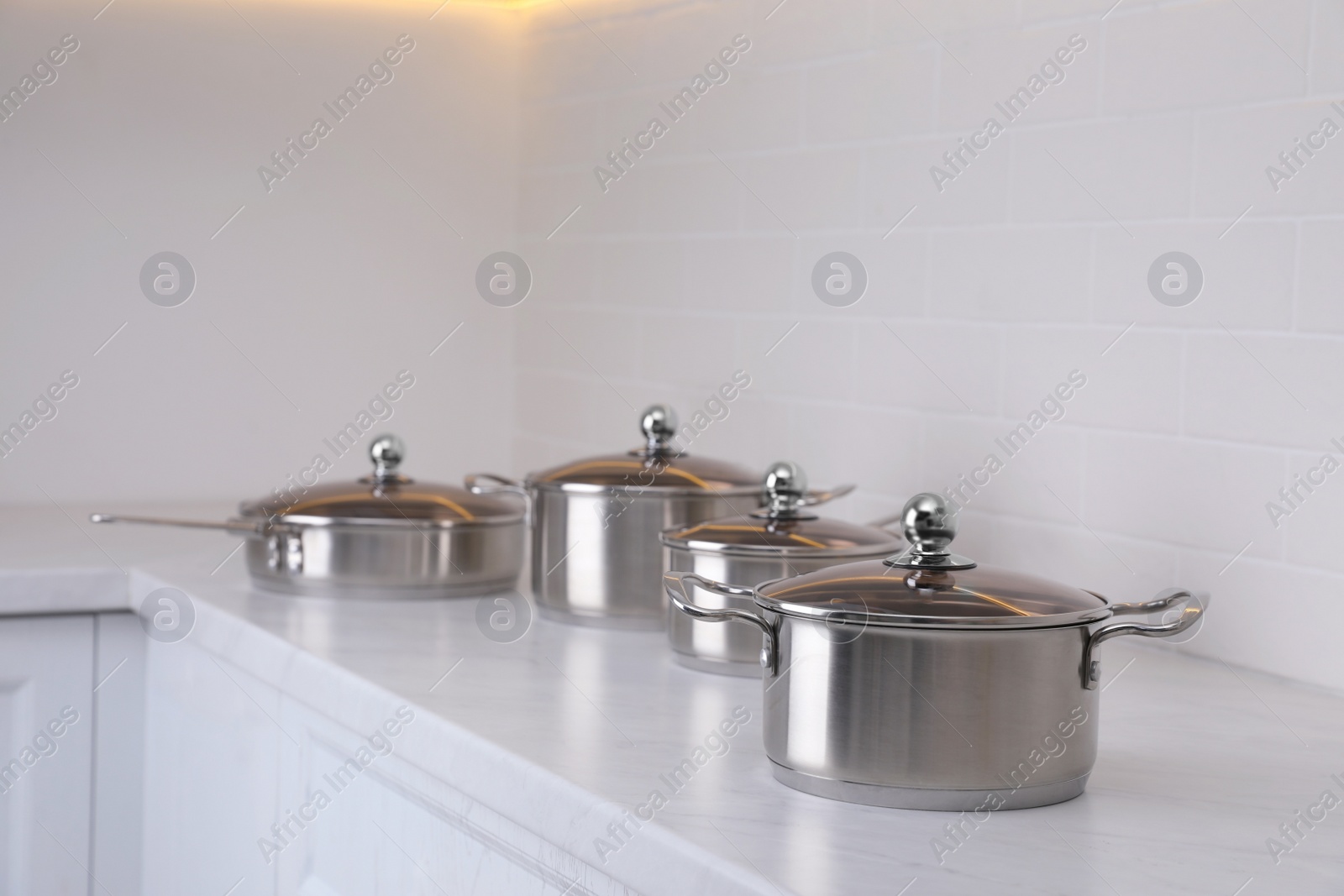 Photo of Set of new clean cookware on countertop in kitchen