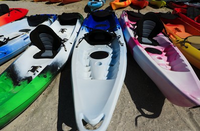 Photo of Many colorful kayaks outdoors on sunny day