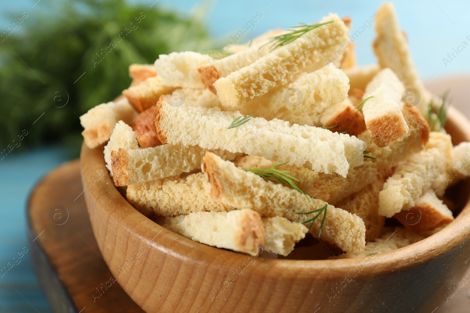 Photo of Delicious hard chucks with dill in wooden bowl, closeup