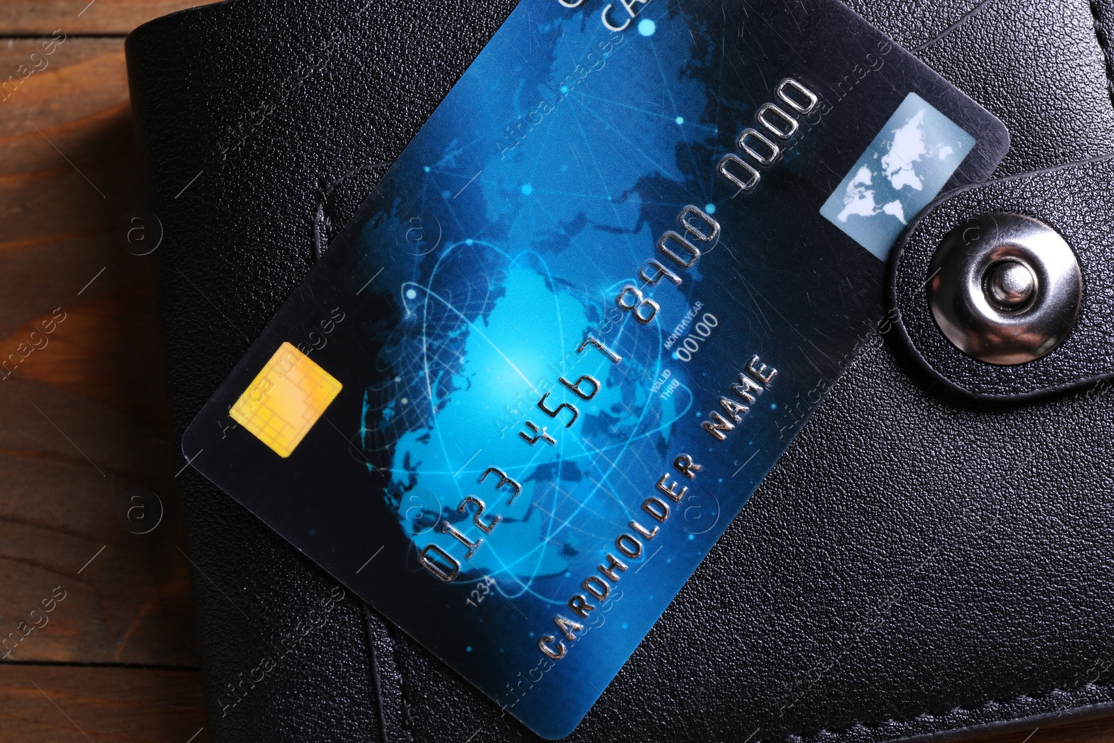 Photo of Credit card and leather wallet on wooden table, top view