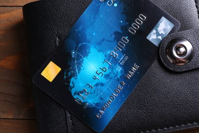 Credit card and leather wallet on wooden table, top view