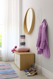 Photo of Stylish hallway interior with round mirror on white wall