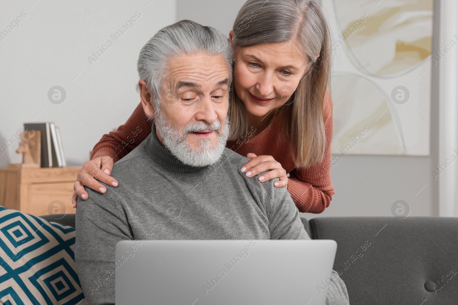 Photo of Elderly couple with laptop discussing pension plan in room