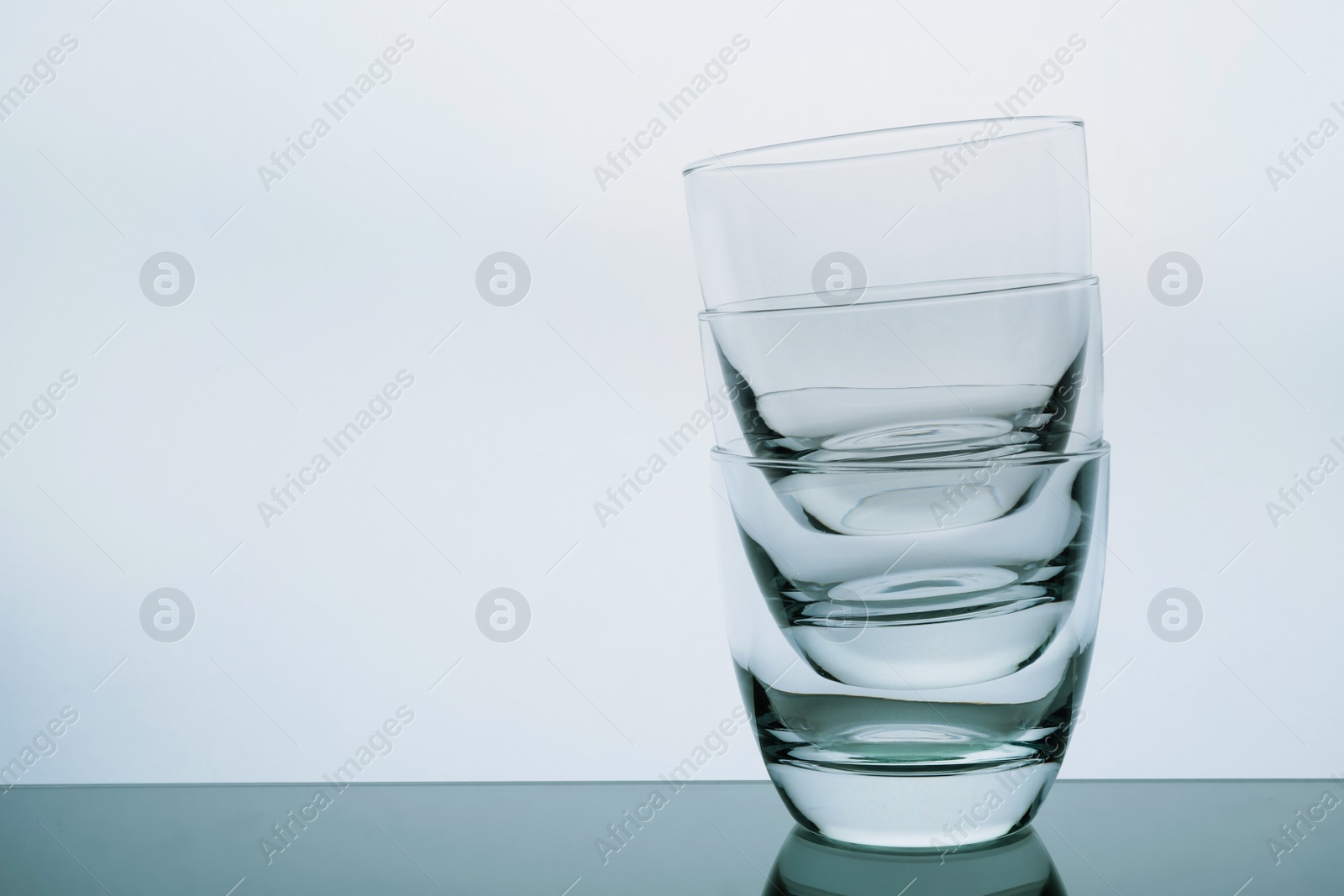 Photo of Stack of empty whiskey glasses on white background