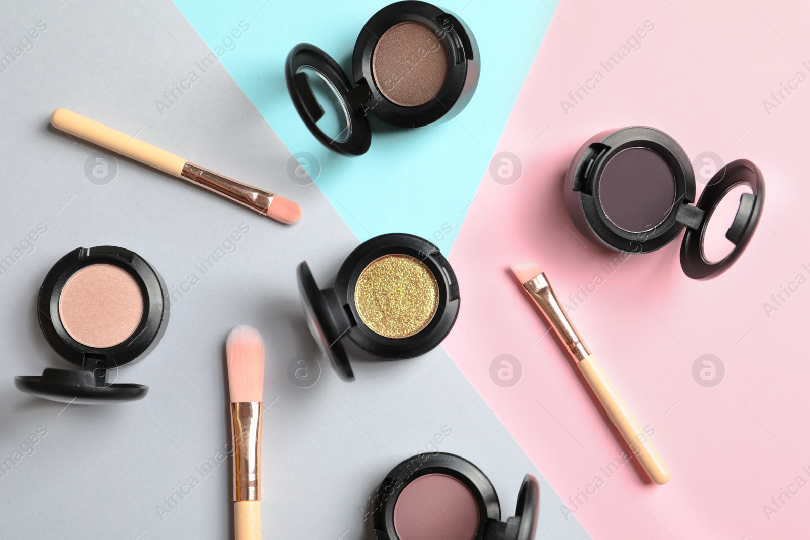 Photo of Flat lay composition with different eye shadows on color background