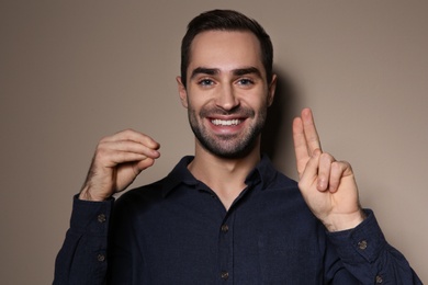 Photo of Man using sign language on color background